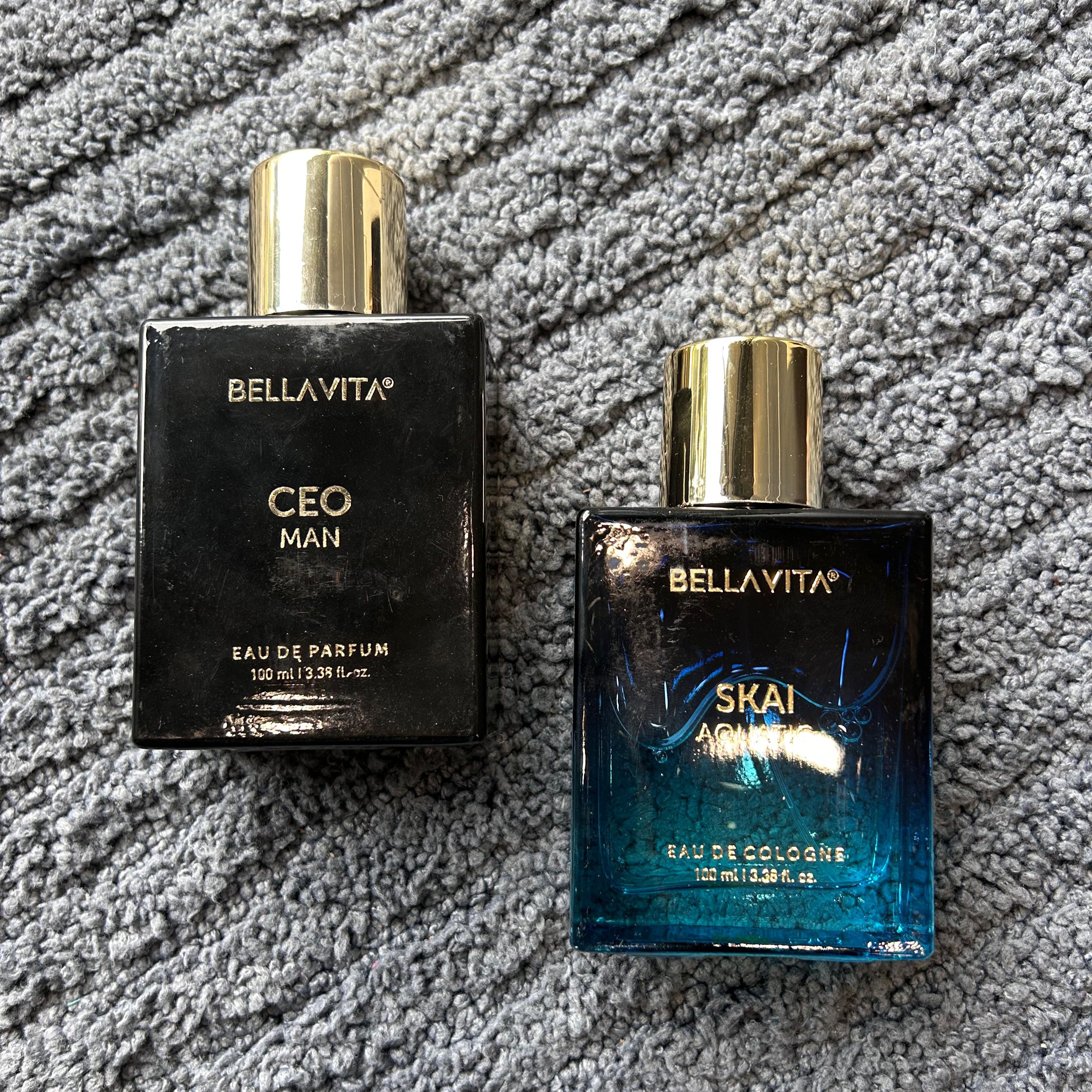 Two BellaVita perfume bottles, one black and one blue, on a textured gray surface. - The Gifting Era