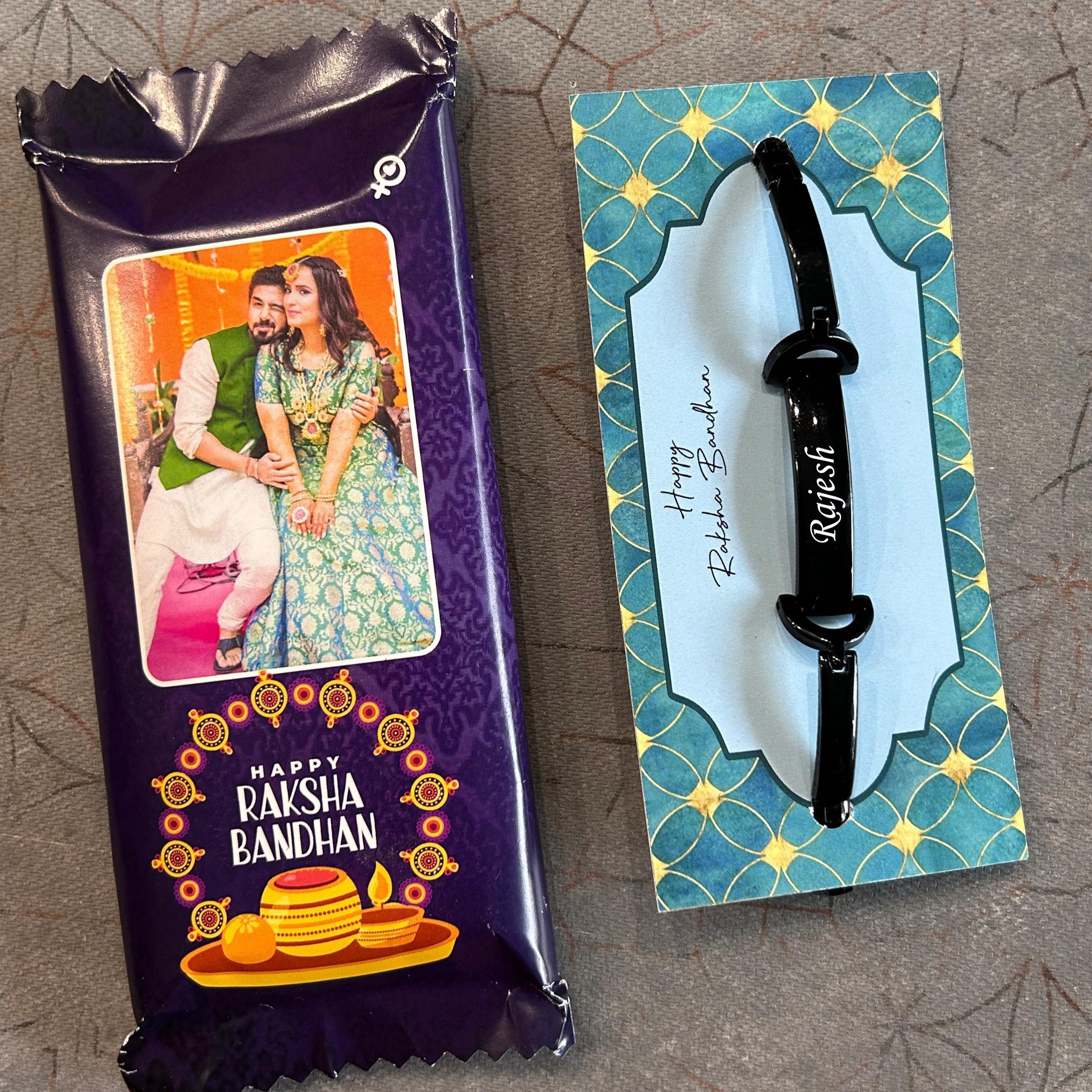 Packaged Rakhi with a card featuring a black rakhi on a textured  surface - The Gifting Era