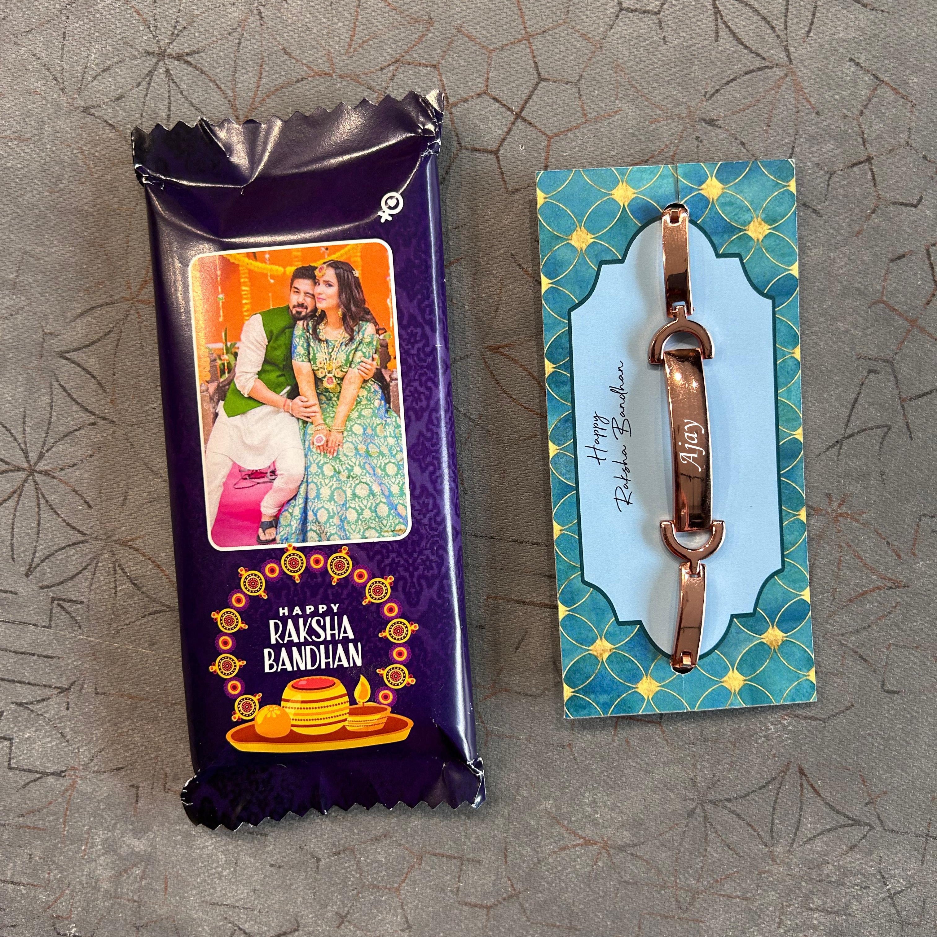 Chocolate bar with a 'Paisa Bandhan' label and a small metal item on a textured surface - The Gifting Era