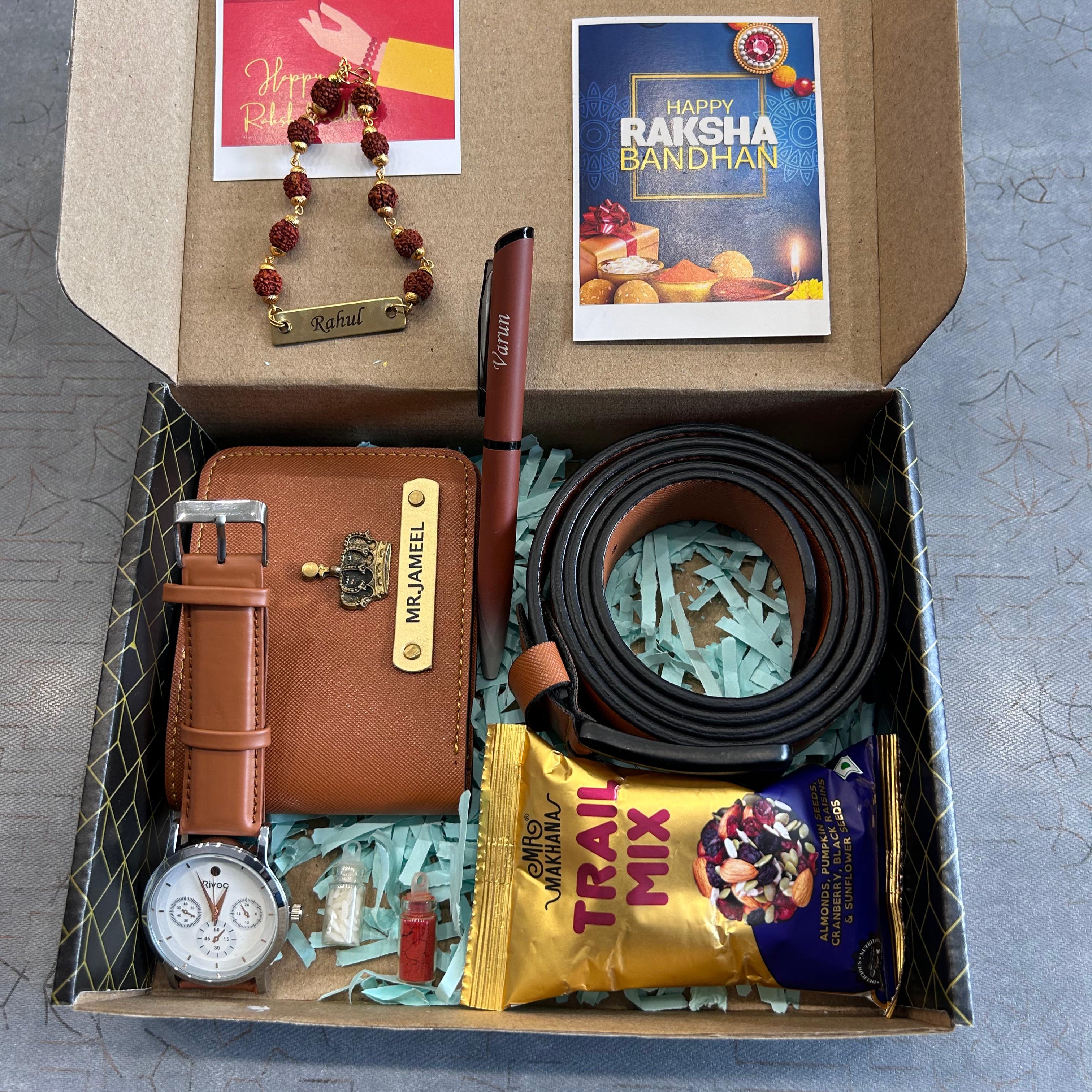 Box containing a watch, belt, wallet, and other items on a gray surface - The Gifting Era