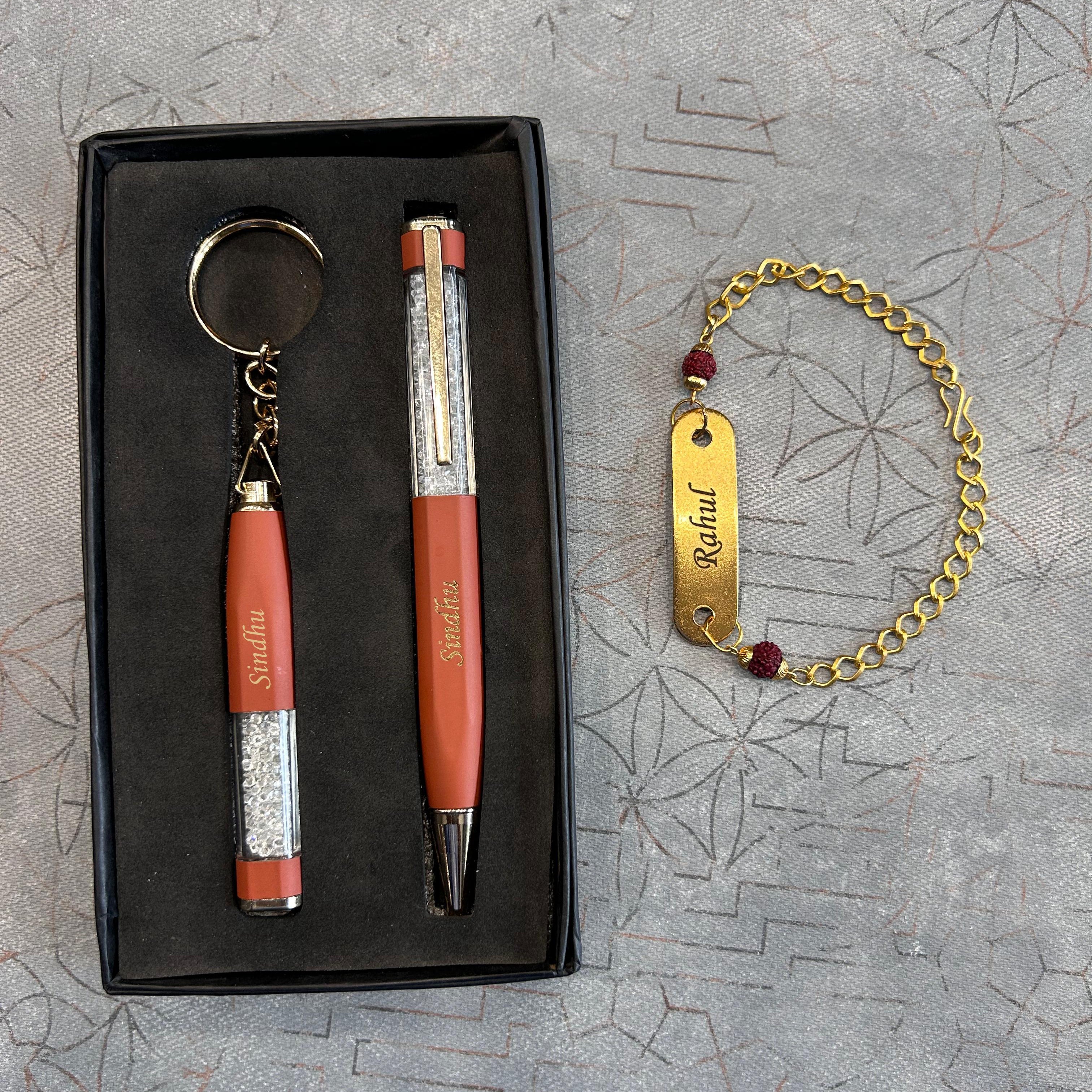 Set of orange pen, keychain, and bracelet on a textured gray surface - The Gifting Era