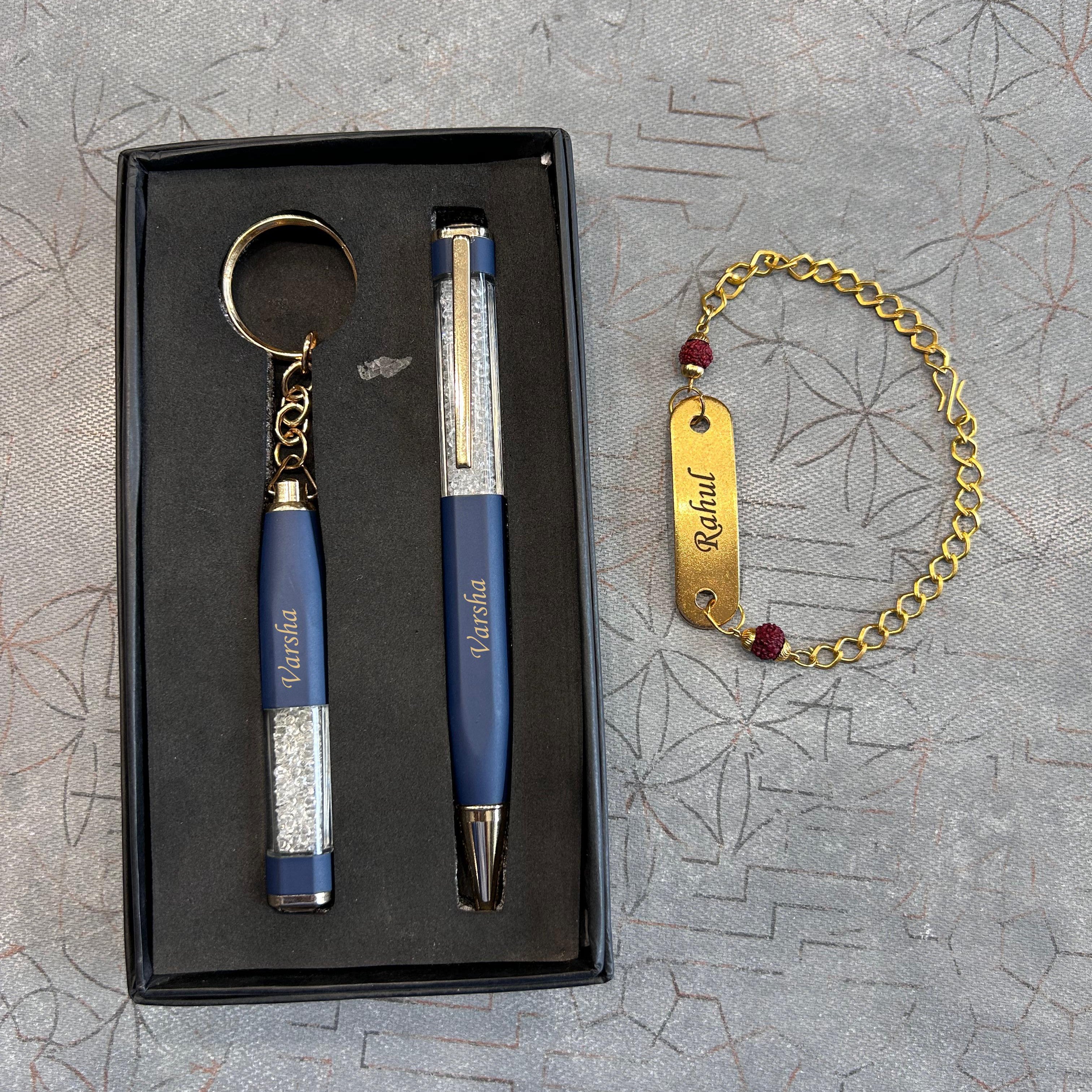 Set of blue pen, keychain, and bracelet on a textured gray surface - The Gifting Era
