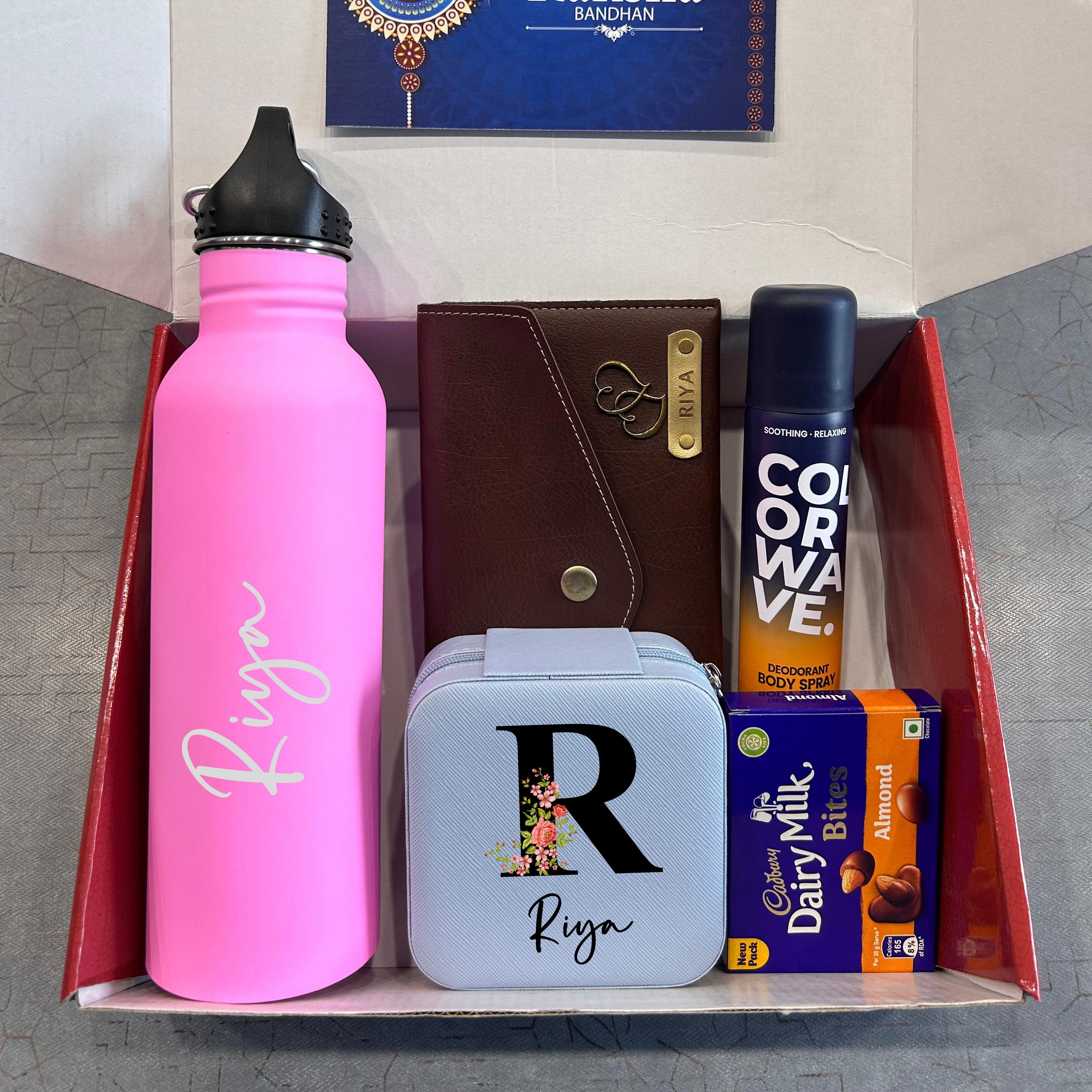 Gift set with pink water bottle, wallet, and snacks with a 'Happy Raksha Bandhan' card. - The Gifting Era
