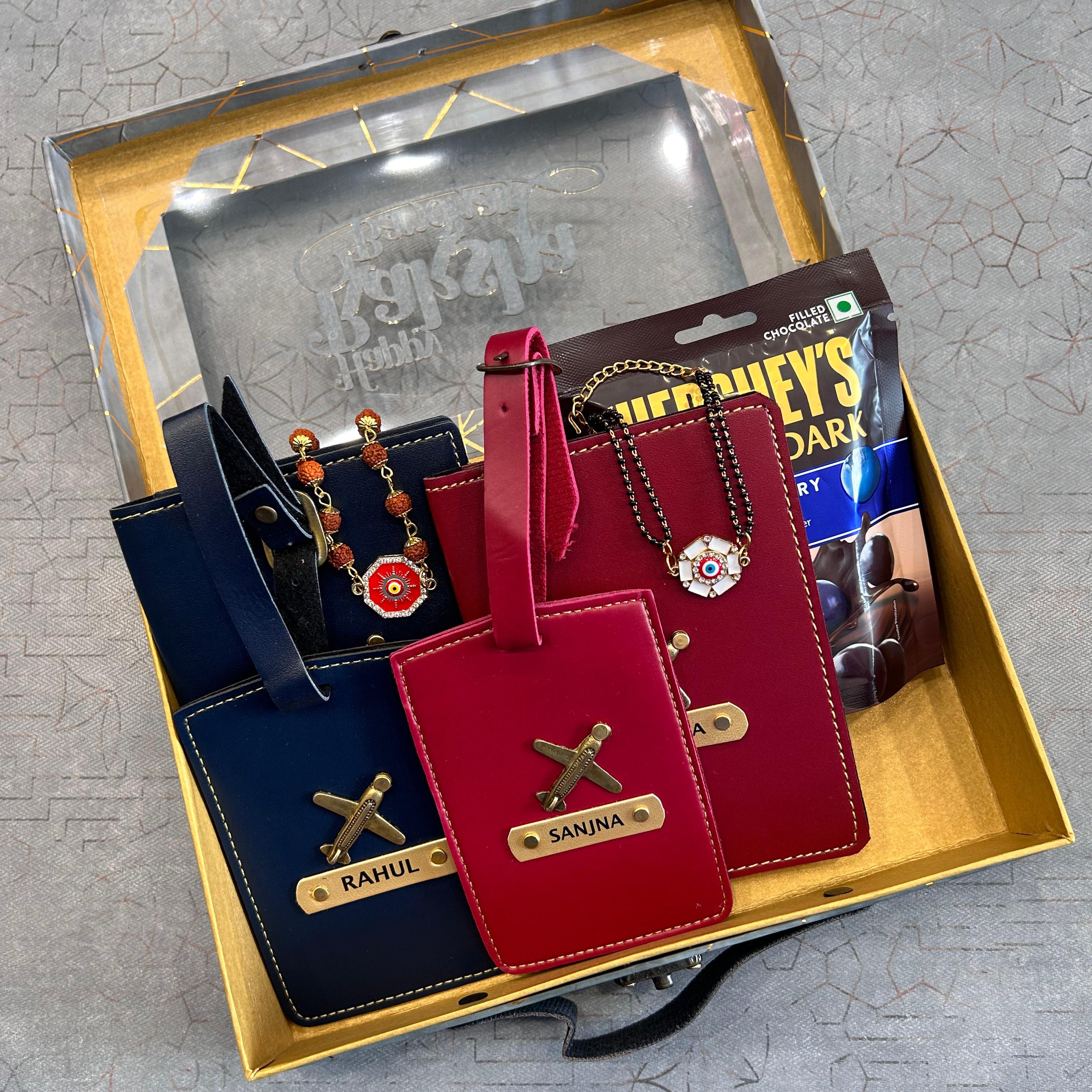 Two luggage tags, one red and one blue, with gold accents on a gray surface. - The Gifting Era