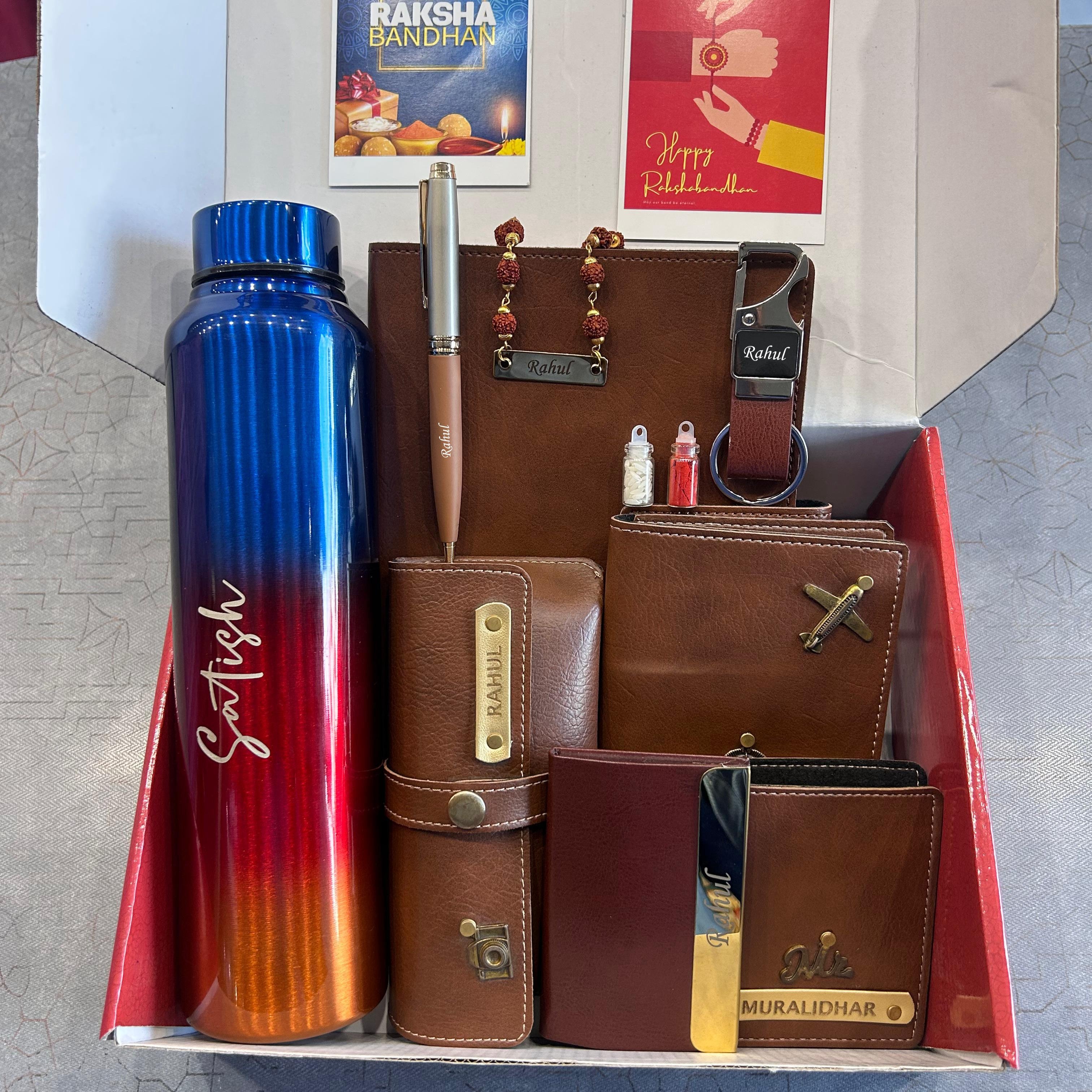 Gift set with a blue and red water bottle, wallets, and other items in an open box. - The Gifting Era