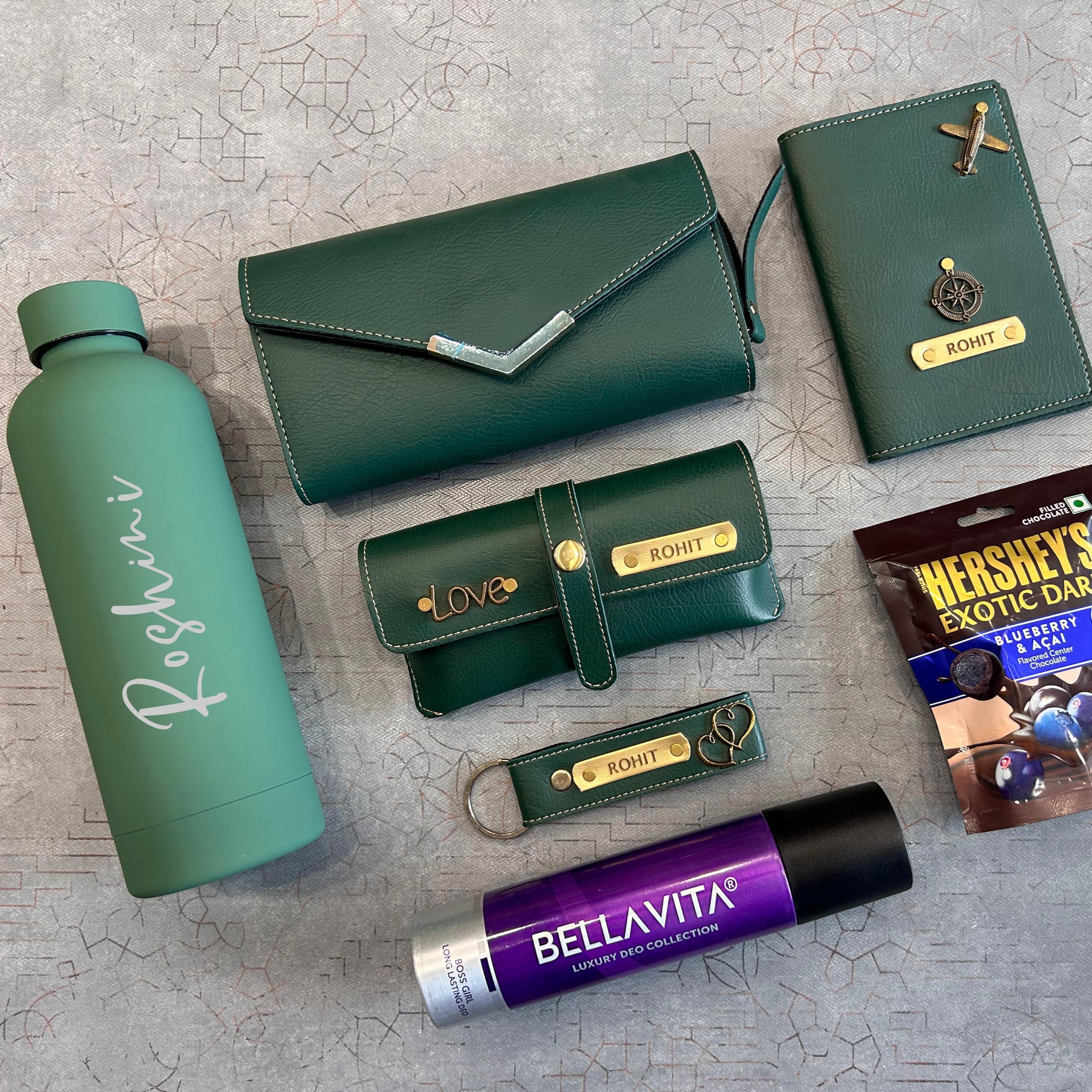 Collection of green and purple items including a water bottle, wallets, and a Hershey's chocolate bar on a textured surface.  - The Gifting Era