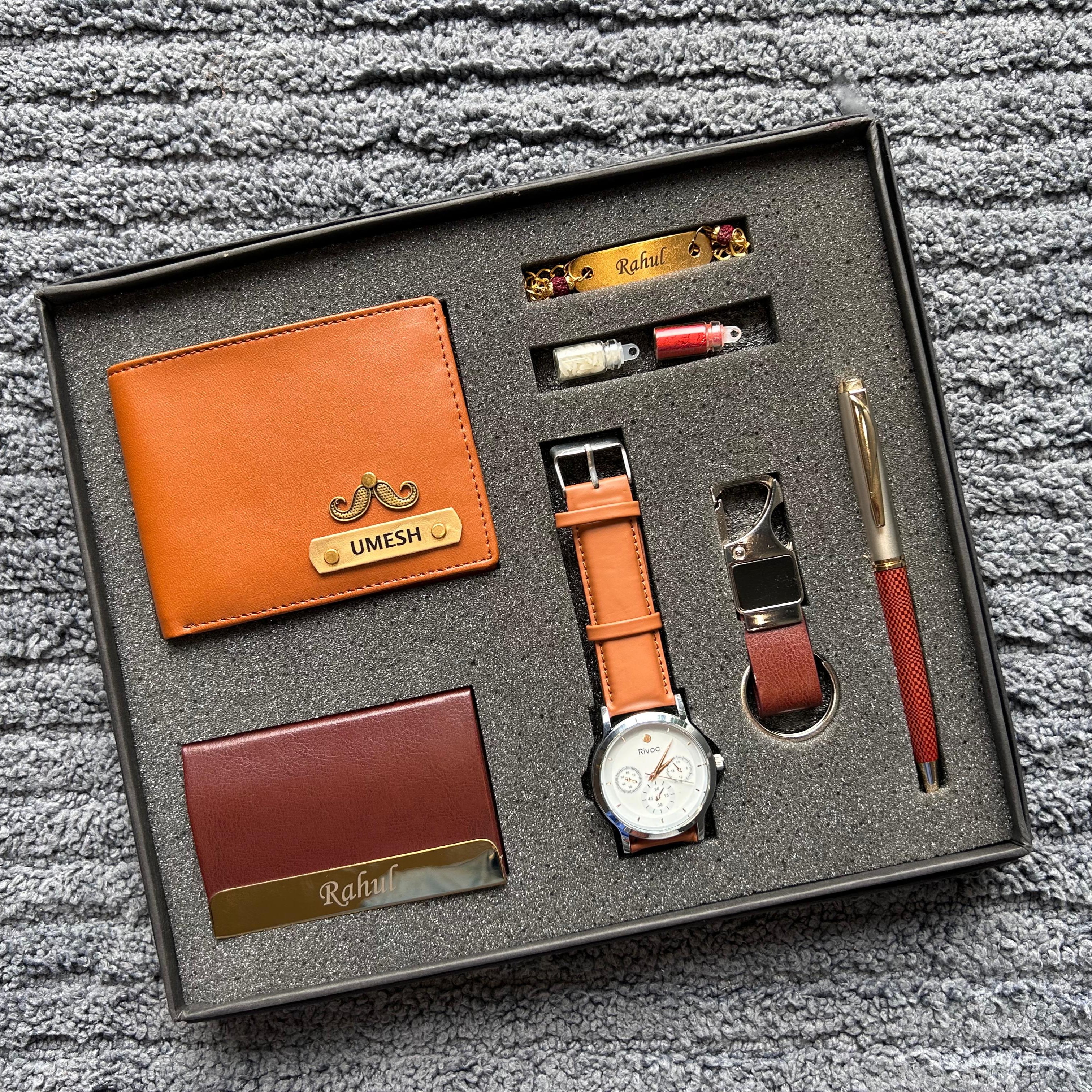 Gift set with leather wallet, watch, pen, and other items in a box on a textured surface. - The gifting Era