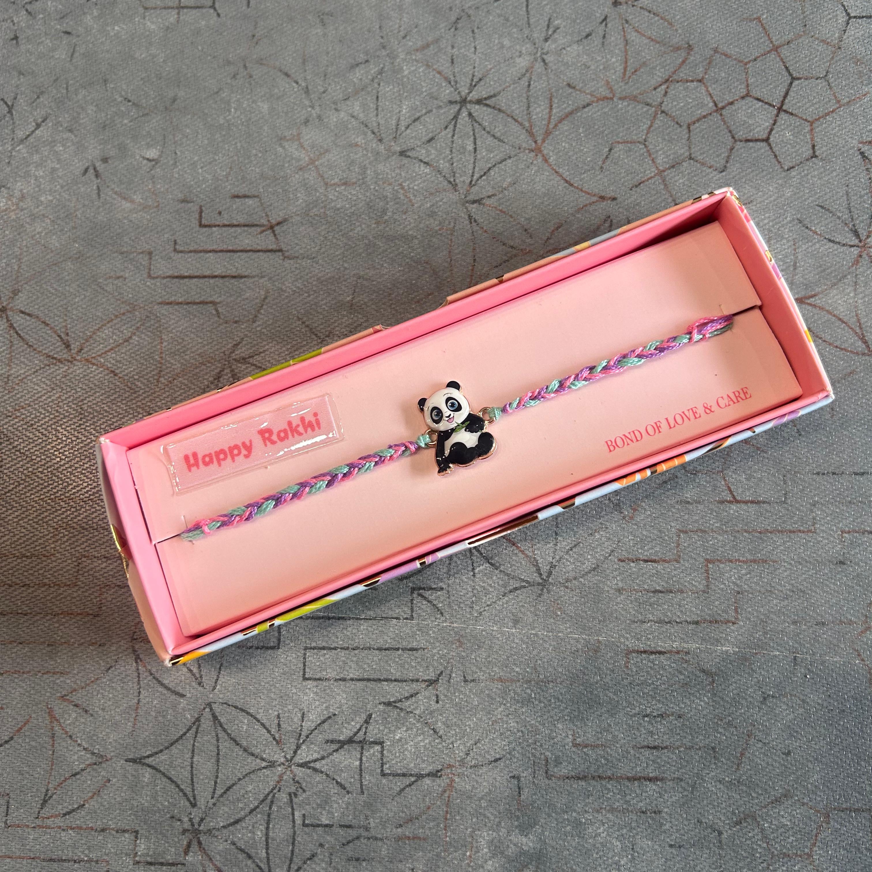 Panda bracelet in a pink box on a textured gray surface - The Gifting Era