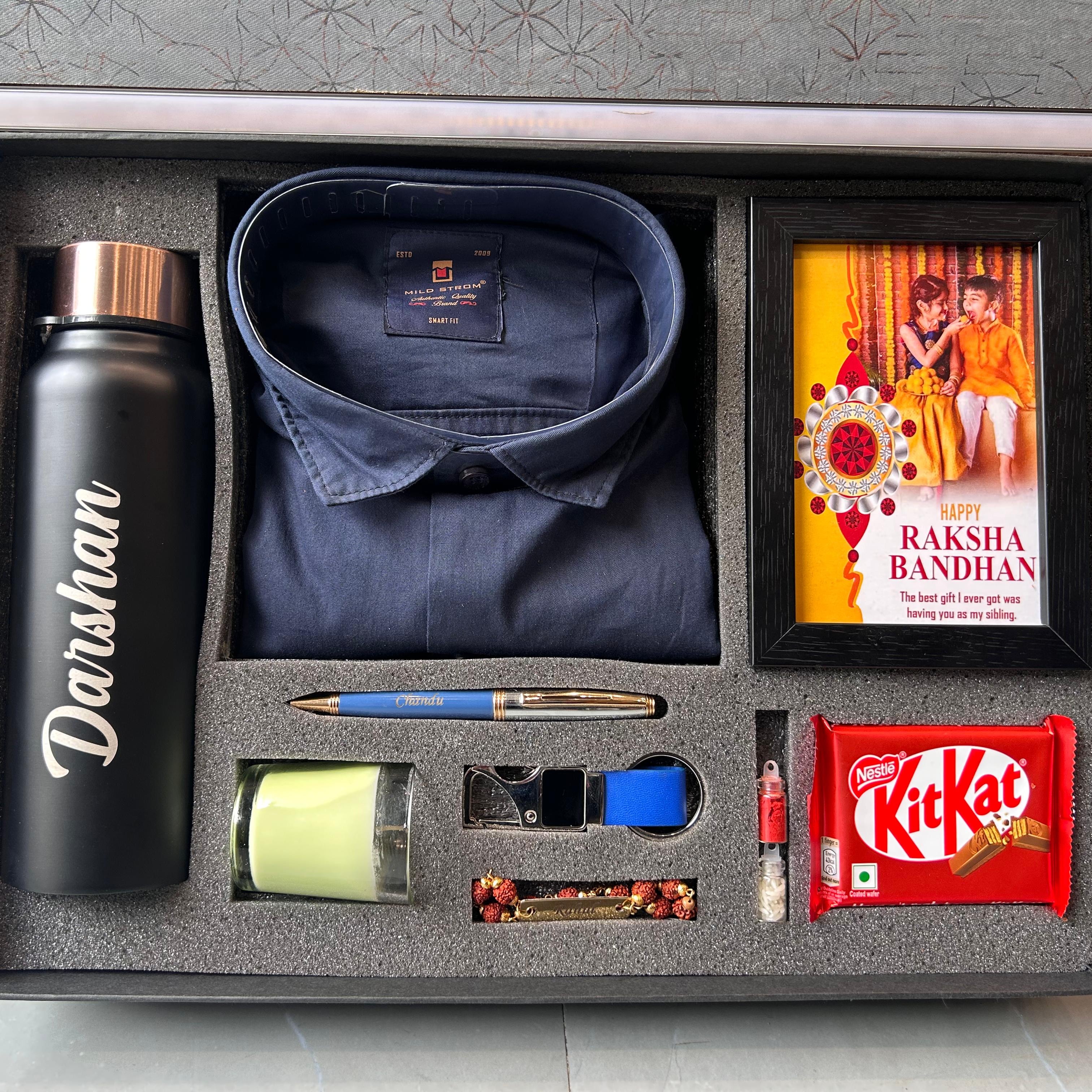 Gift set with navy shirt, water bottle, Raksha Bandhan card, and KitKat bar in a box. - The Gifting Era