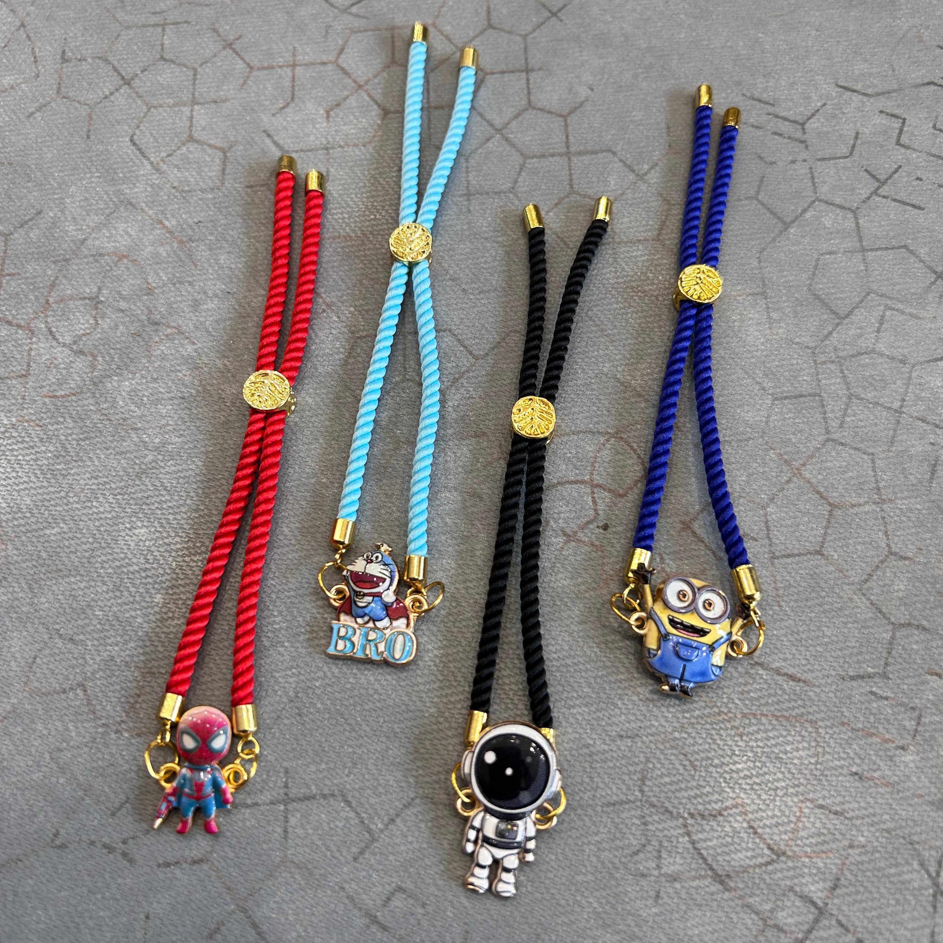 Four colorful bracelets with charms on a textured gray surface